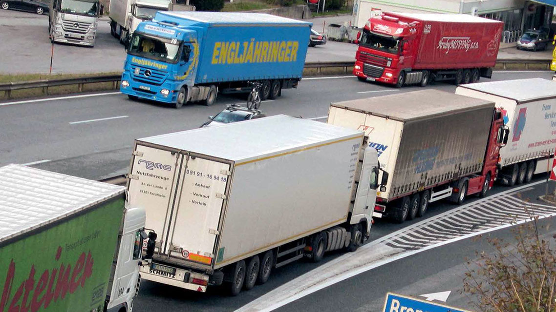 Una fila de camiones circulando por una autopista, destacando el papel de Kapsch en el transporte de mercancías.