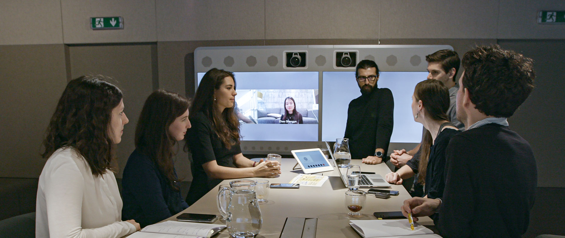 Eine Gruppe von Menschen sitzt um einen Tisch in einem Büro.