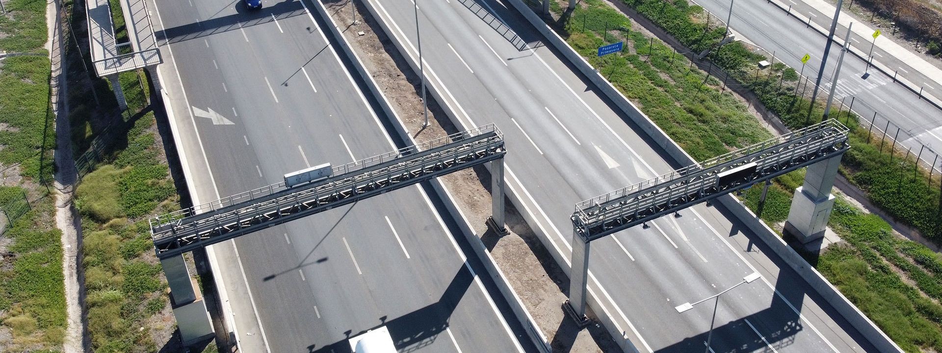 Highway with cars driving under toll gantries