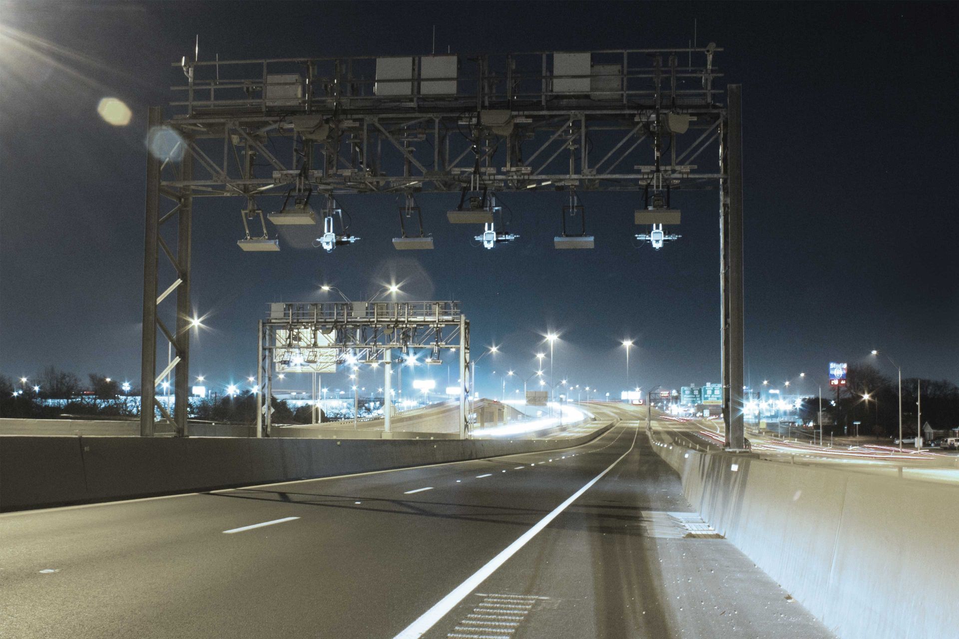 Eine beleuchtete Straße mit einer Brücke bei Nacht.