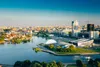 Aerial view of a city skyline with a body of water in the foreground, showcasing urban development and natural elements.