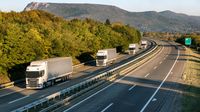 Eine Gruppe von Lastwagen auf einer Autobahn.