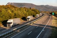 Eine Gruppe von Lastwagen auf einer Autobahn.