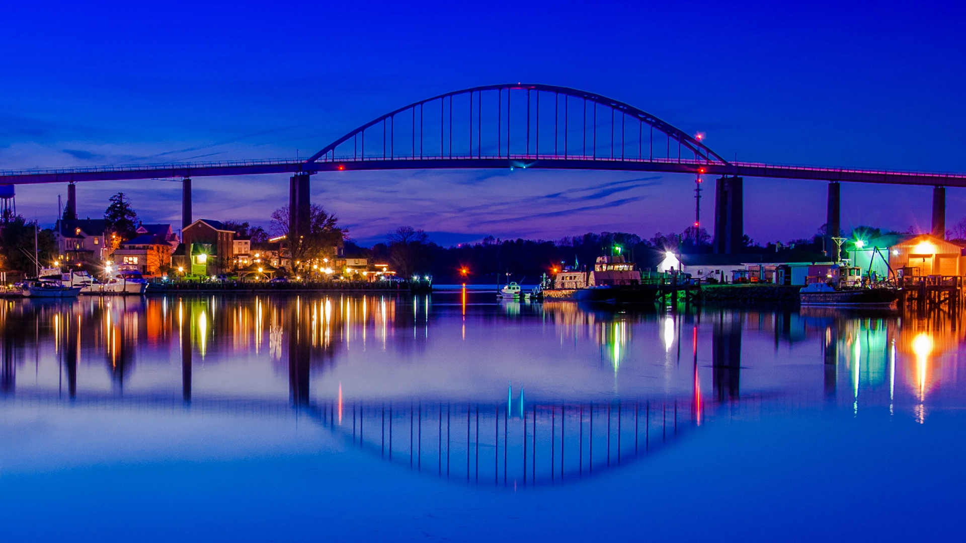 Bridge over water at night with reflections on the surface.