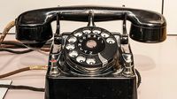 Primer plano de un teléfono con cable, destacado por su diseño clásico.