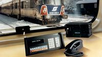 Un teléfono antiguo y un modelo de tren en una mesa, representando la historia tecnológica de Kapsch.