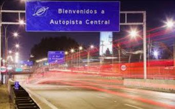 Blaues Straßenschild bei Nacht auf einer Straße.