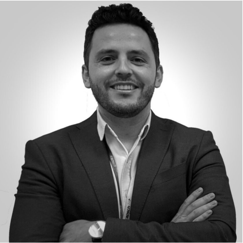 Ein Mann mit verschränkten Armen lächelt.