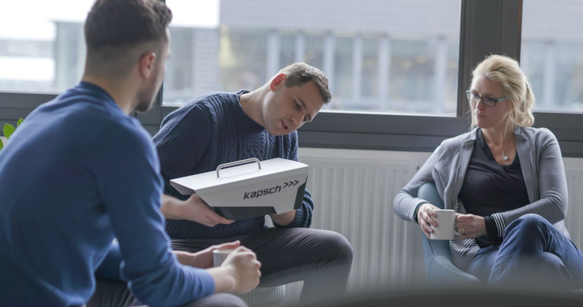 Eine Gruppe von Menschen sitzt um einen Tisch und unterhält sich.