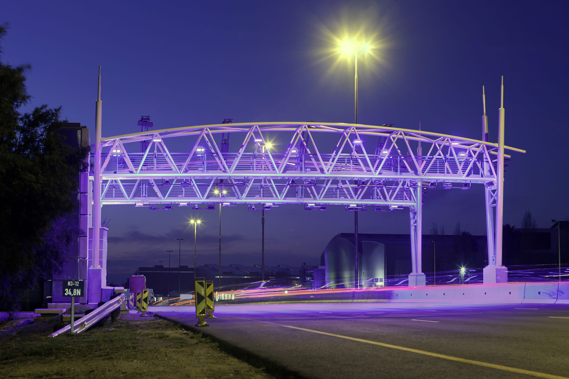 A toll booth illuminated at night, highlighting Kapsch TrafficCom's location-based charging solutions