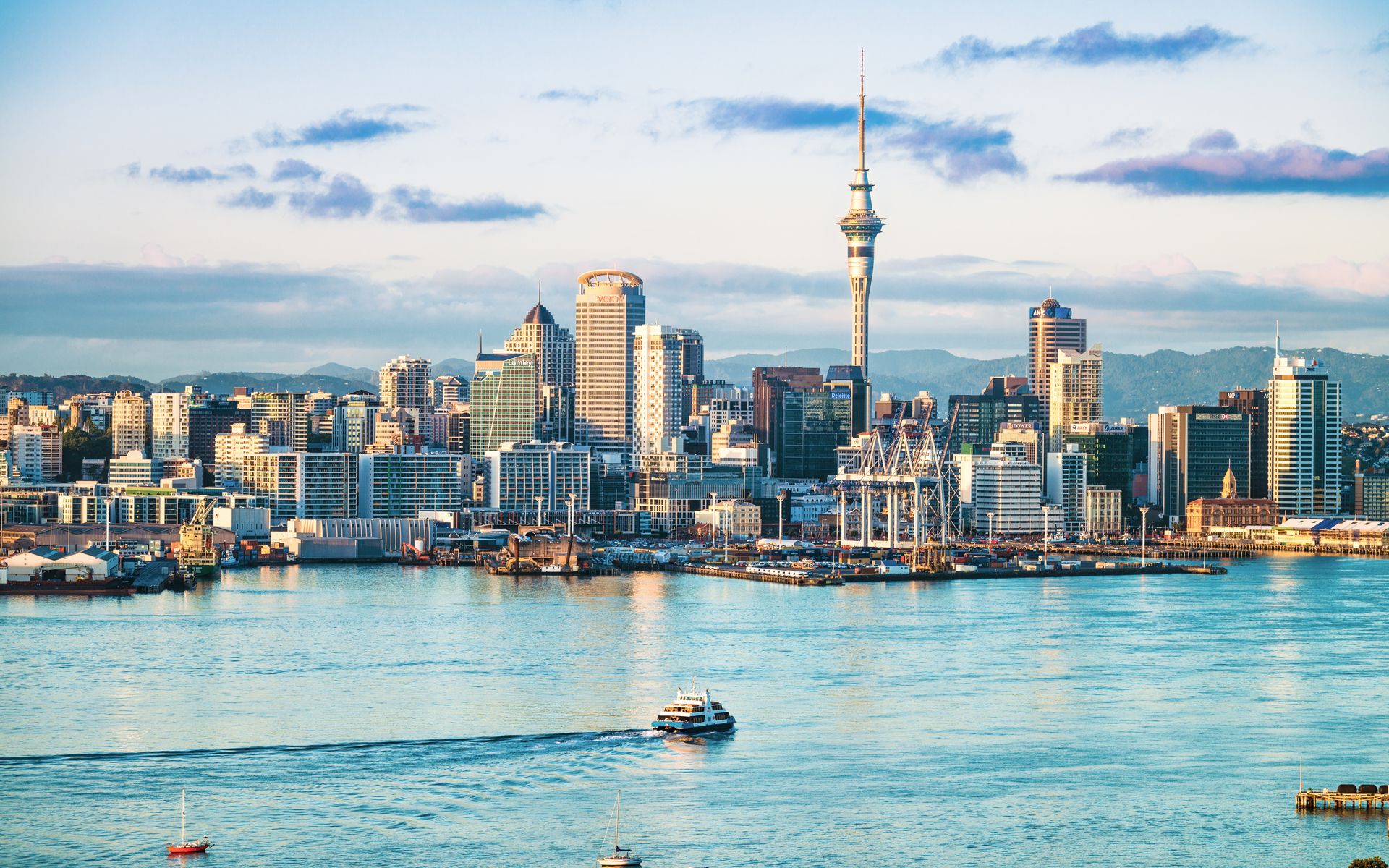City skyline with a body of water and clouds in the sky.