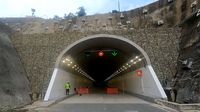 Ein Mann geht durch einen Tunnel mit Steinmauer.