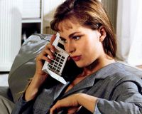 Una mujer sosteniendo una calculadora en un entorno interior, en el contexto de la historia empresarial de Kapsch.