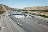 A highway with cars and a bridge, showcasing Kapsch TrafficCom's advanced infrastructure solutions for efficient traffic management.