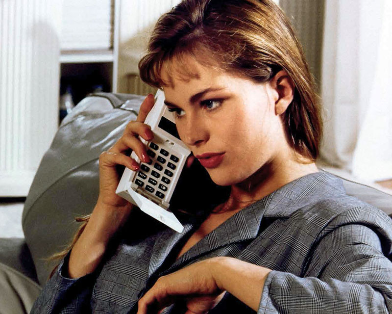 Una mujer sosteniendo una calculadora en un entorno interior, en el contexto de la historia empresarial de Kapsch.