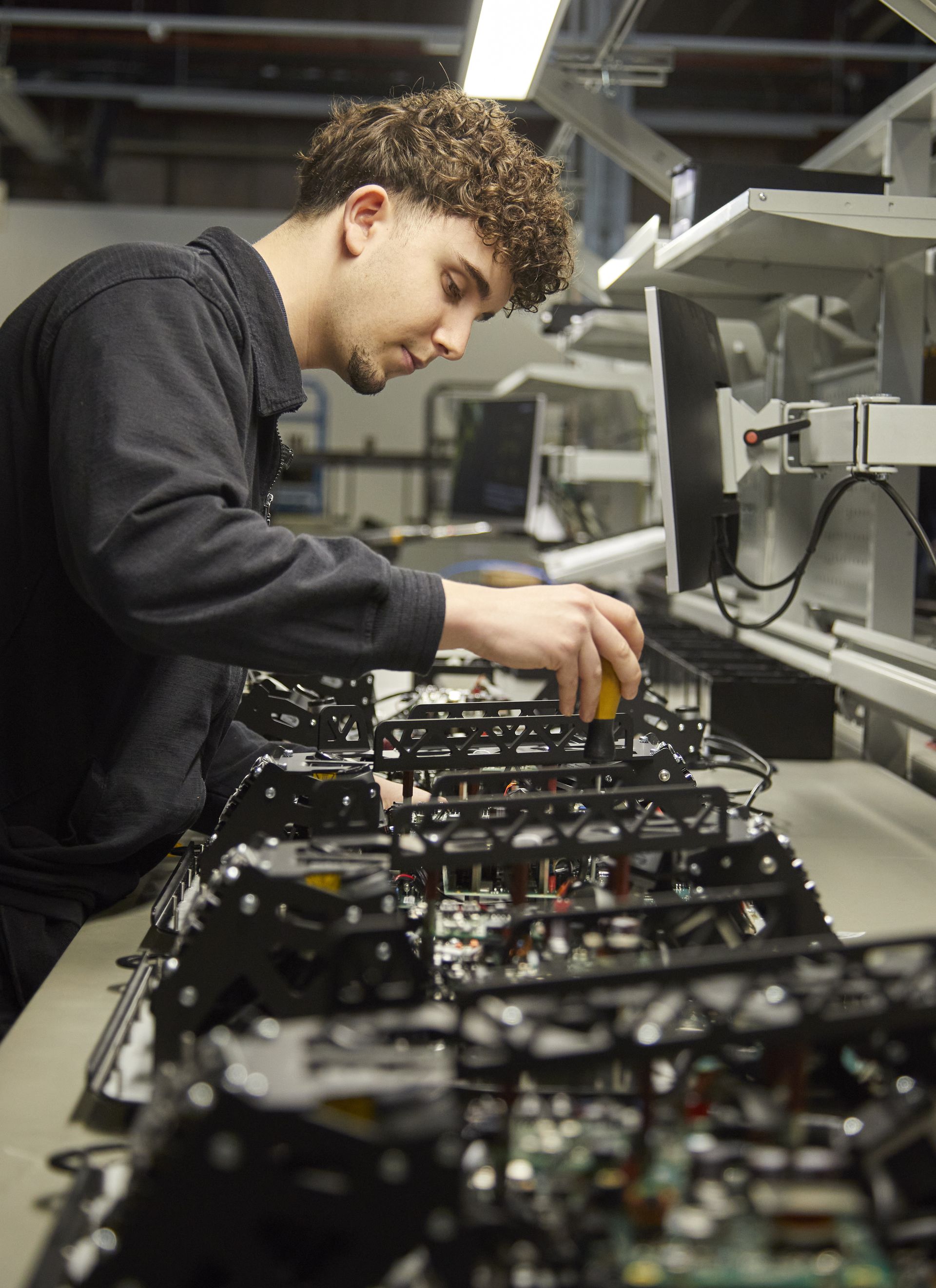 © @ Kapsch TrafficCom Ein Arbeiter, der eine Reihe von Produkten manuell prüft