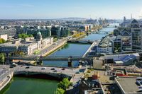 Vista aérea de una ciudad con un puente sobre el agua, destacando el entorno urbano y la infraestructura de transporte.