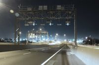 Eine beleuchtete Straße mit einer Brücke bei Nacht.