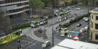 City street with cars and buses in traffic.