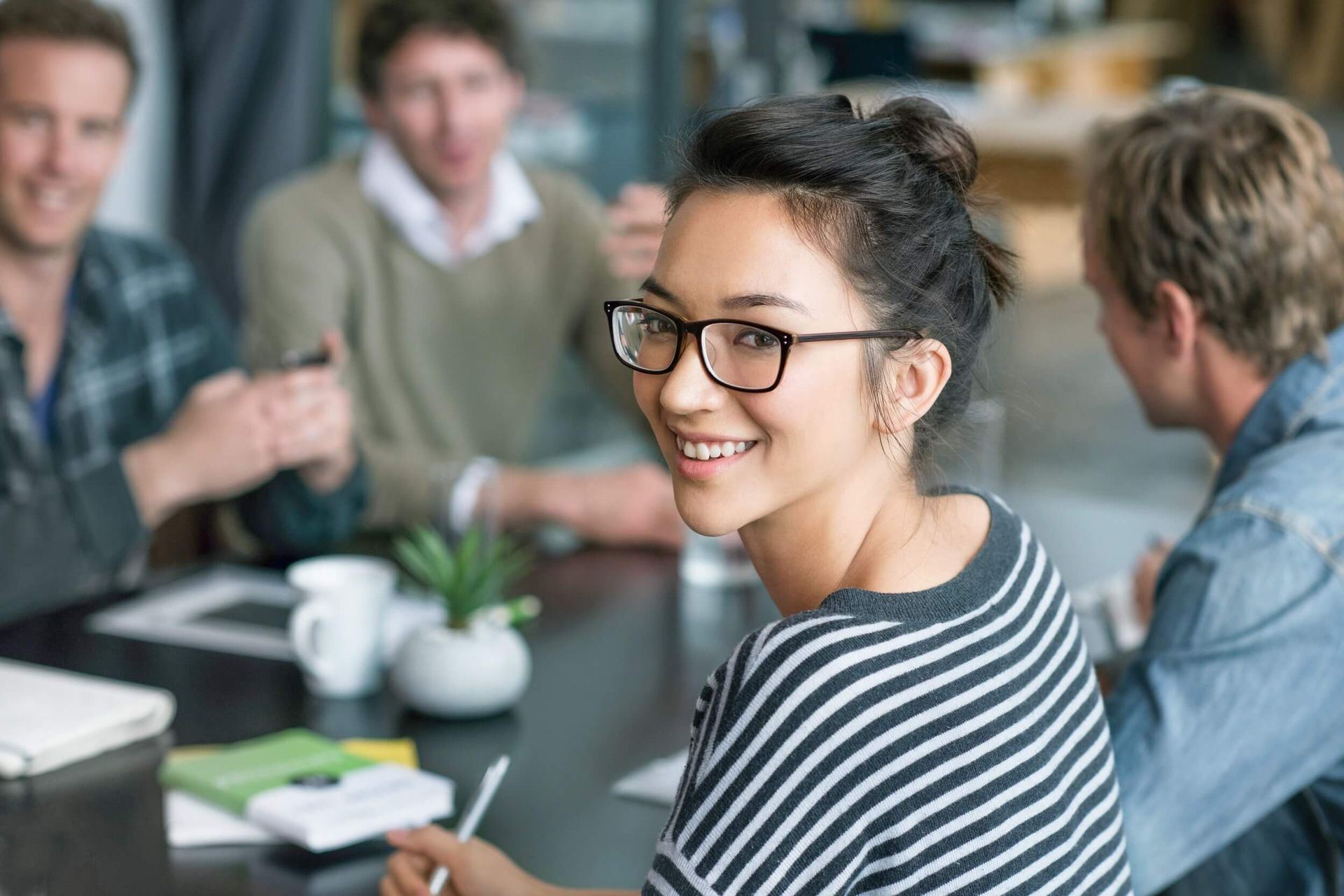A woman smiling confidently, representing the diverse and inclusive work environment at Kapsch TrafficCom Austria.
