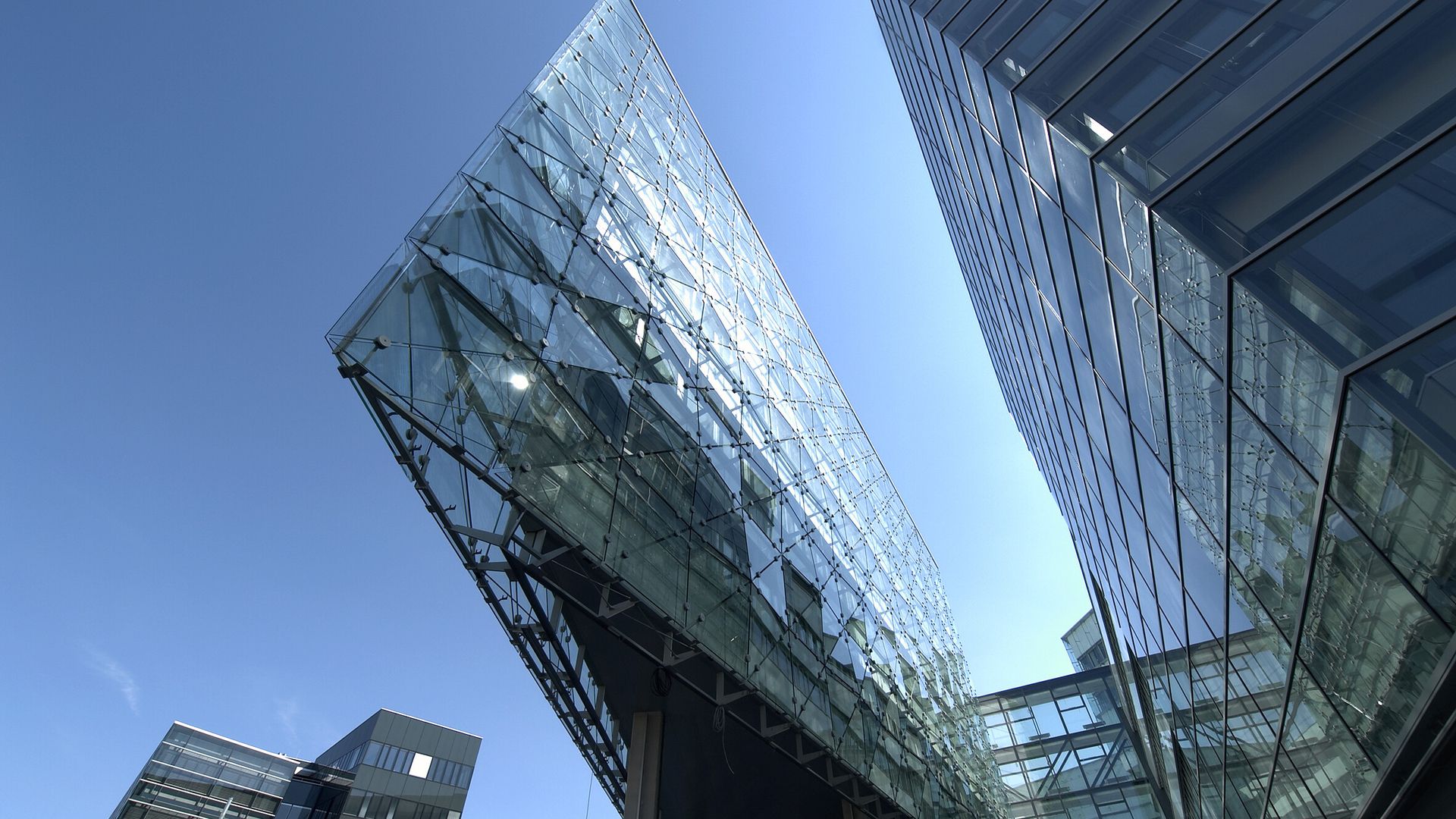Glass-walled commercial building against a clear sky.