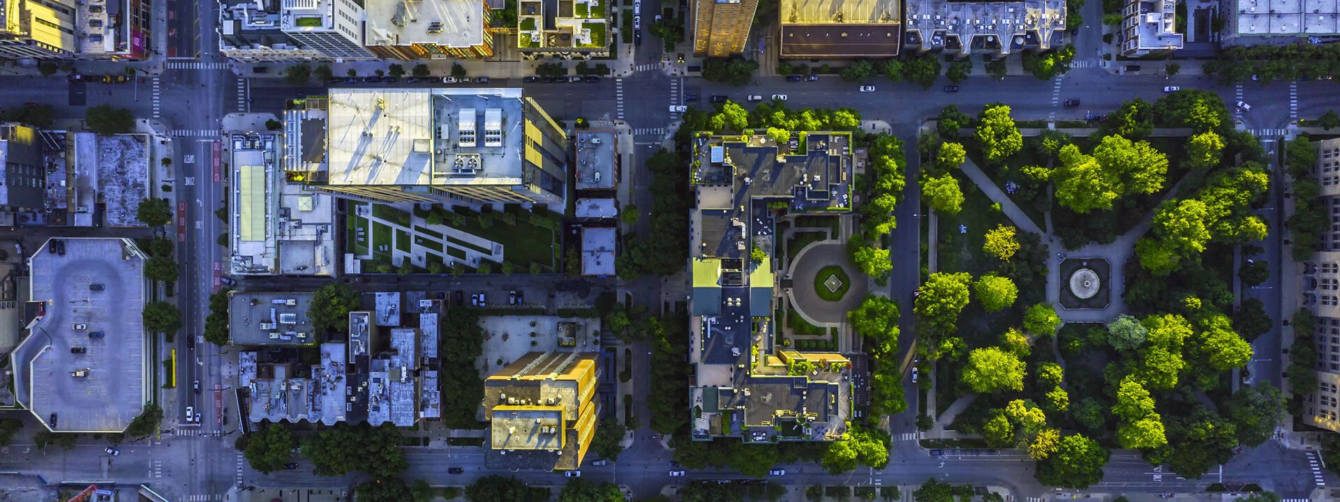 Aerial view of a city with buildings and trees, highlighting urbanization and air quality challenges.