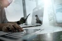 Eine Person benutzt einen Laptop und ein Telefon.
